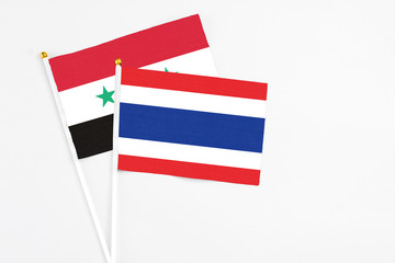 Thailand and Syria stick flags on white background. High quality fabric, miniature national flag....