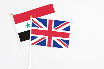 United Kingdom and Syria stick flags on white background. High quality fabric, miniature national...