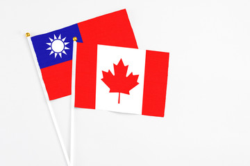 Fototapeta na wymiar Canada and Taiwan stick flags on white background. High quality fabric, miniature national flag. Peaceful global concept.White floor for copy space.