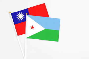 Djibouti and Taiwan stick flags on white background. High quality fabric, miniature national flag. Peaceful global concept.White floor for copy space.