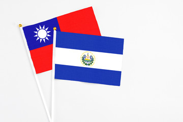 El Salvador and Taiwan stick flags on white background. High quality fabric, miniature national flag. Peaceful global concept.White floor for copy space.