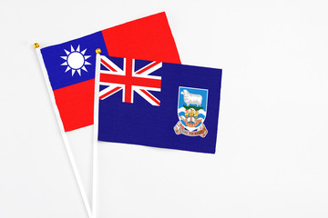 Fototapeta premium Falkland Islands and Taiwan stick flags on white background. High quality fabric, miniature national flag. Peaceful global concept.White floor for copy space.