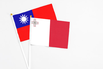 Malta and Taiwan stick flags on white background. High quality fabric, miniature national flag. Peaceful global concept.White floor for copy space.