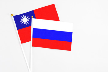 Russia and Taiwan stick flags on white background. High quality fabric, miniature national flag. Peaceful global concept.White floor for copy space.