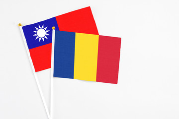 Fototapeta premium Romania and Taiwan stick flags on white background. High quality fabric, miniature national flag. Peaceful global concept.White floor for copy space.