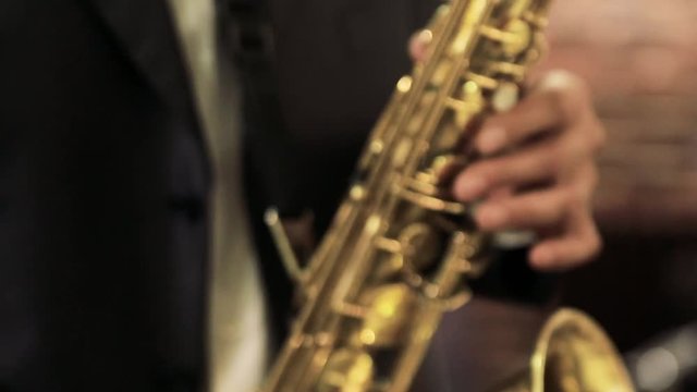 a man plays the saxophone. Playing the saxophone close up