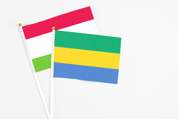 Gabon and Tajikistan stick flags on white background. High quality fabric, miniature national flag. Peaceful global concept.White floor for copy space.