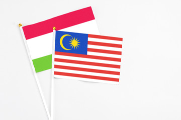 Malaysia and Tajikistan stick flags on white background. High quality fabric, miniature national flag. Peaceful global concept.White floor for copy space.