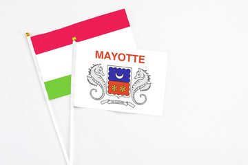 Mayotte and Tajikistan stick flags on white background. High quality fabric, miniature national flag. Peaceful global concept.White floor for copy space.