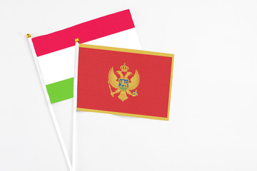 Montenegro and Tajikistan stick flags on white background. High quality fabric, miniature national flag. Peaceful global concept.White floor for copy space.