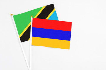 Armenia and Tanzania stick flags on white background. High quality fabric, miniature national flag. Peaceful global concept.White floor for copy space.