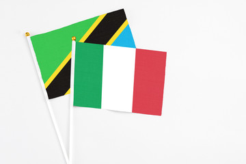 Italy and Tanzania stick flags on white background. High quality fabric, miniature national flag. Peaceful global concept.White floor for copy space.