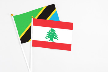 Lebanon and Tanzania stick flags on white background. High quality fabric, miniature national flag. Peaceful global concept.White floor for copy space.