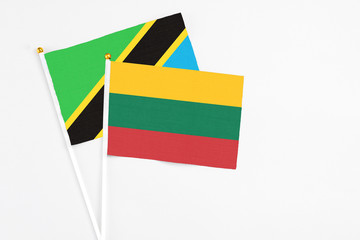 Lithuania and Tanzania stick flags on white background. High quality fabric, miniature national flag. Peaceful global concept.White floor for copy space.