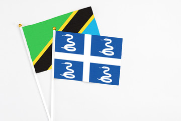 Martinique and Tanzania stick flags on white background. High quality fabric, miniature national flag. Peaceful global concept.White floor for copy space.