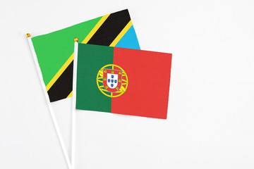 Portugal and Tanzania stick flags on white background. High quality fabric, miniature national flag. Peaceful global concept.White floor for copy space.