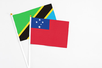 Samoa and Tanzania stick flags on white background. High quality fabric, miniature national flag. Peaceful global concept.White floor for copy space.