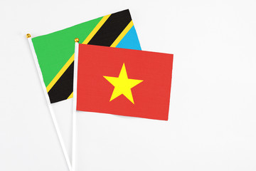 Vietnam and Tanzania stick flags on white background. High quality fabric, miniature national flag. Peaceful global concept.White floor for copy space.