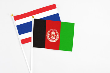 Afghanistan and Thailand stick flags on white background. High quality fabric, miniature national flag. Peaceful global concept.White floor for copy space.