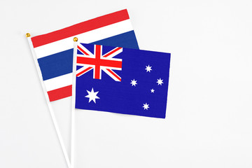 Fototapeta premium Australia and Thailand stick flags on white background. High quality fabric, miniature national flag. Peaceful global concept.White floor for copy space.