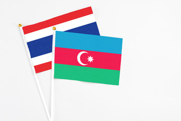 Azerbaijan and Thailand stick flags on white background. High quality fabric, miniature national flag. Peaceful global concept.White floor for copy space.