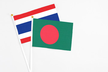 Bangladesh and Thailand stick flags on white background. High quality fabric, miniature national flag. Peaceful global concept.White floor for copy space.