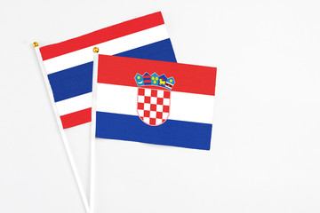 Croatia and Thailand stick flags on white background. High quality fabric, miniature national flag. Peaceful global concept.White floor for copy space.