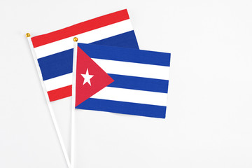 Cuba and Thailand stick flags on white background. High quality fabric, miniature national flag. Peaceful global concept.White floor for copy space.