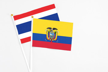 Ecuador and Thailand stick flags on white background. High quality fabric, miniature national flag. Peaceful global concept.White floor for copy space.