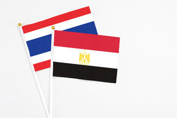 Egypt and Thailand stick flags on white background. High quality fabric, miniature national flag. Peaceful global concept.White floor for copy space.