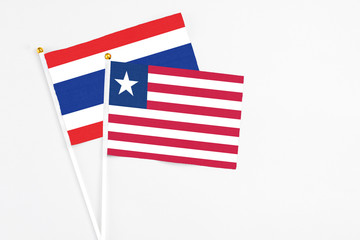 Liberia and Thailand stick flags on white background. High quality fabric, miniature national flag. Peaceful global concept.White floor for copy space.