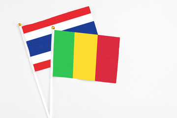 Mali and Thailand stick flags on white background. High quality fabric, miniature national flag. Peaceful global concept.White floor for copy space.