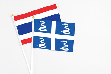 Martinique and Thailand stick flags on white background. High quality fabric, miniature national flag. Peaceful global concept.White floor for copy space.