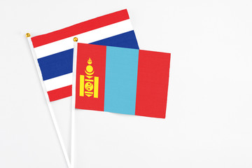 Naklejka premium Mongolia and Thailand stick flags on white background. High quality fabric, miniature national flag. Peaceful global concept.White floor for copy space.