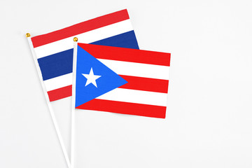 Fototapeta premium Puerto Rico and Thailand stick flags on white background. High quality fabric, miniature national flag. Peaceful global concept.White floor for copy space.