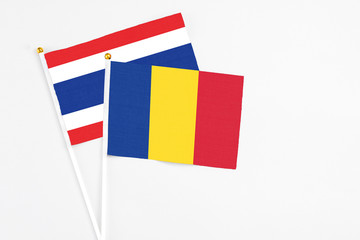 Romania and Thailand stick flags on white background. High quality fabric, miniature national flag. Peaceful global concept.White floor for copy space.