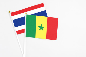 Senegal and Thailand stick flags on white background. High quality fabric, miniature national flag. Peaceful global concept.White floor for copy space.