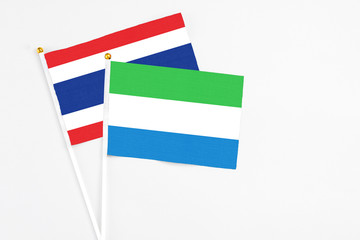 Sierra Leone and Thailand stick flags on white background. High quality fabric, miniature national flag. Peaceful global concept.White floor for copy space.