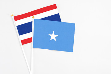 Somalia and Thailand stick flags on white background. High quality fabric, miniature national flag. Peaceful global concept.White floor for copy space.