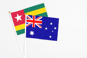 Fototapeta premium Australia and Togo stick flags on white background. High quality fabric, miniature national flag. Peaceful global concept.White floor for copy space.