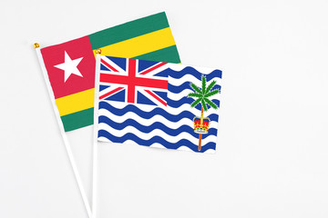 British Indian Ocean Territory and Togo stick flags on white background. High quality fabric, miniature national flag. Peaceful global concept.White floor for copy space.