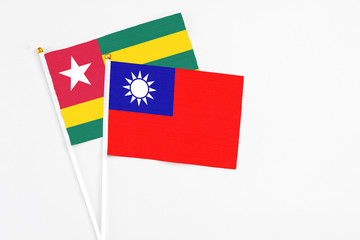 Taiwan and Togo stick flags on white background. High quality fabric, miniature national flag. Peaceful global concept.White floor for copy space.