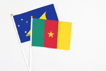 Cameroon and Tokelau stick flags on white background. High quality fabric, miniature national flag. Peaceful global concept.White floor for copy space.