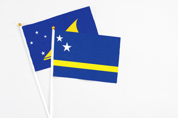 Curacao and Tokelau stick flags on white background. High quality fabric, miniature national flag. Peaceful global concept.White floor for copy space.