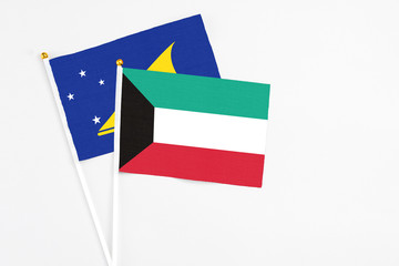 Kuwait and Tokelau stick flags on white background. High quality fabric, miniature national flag. Peaceful global concept.White floor for copy space.