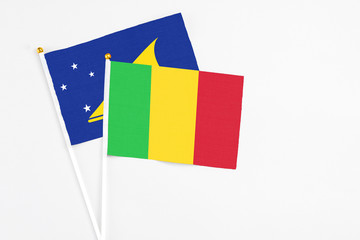 Mali and Tokelau stick flags on white background. High quality fabric, miniature national flag. Peaceful global concept.White floor for copy space.