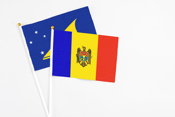 Moldova and Tokelau stick flags on white background. High quality fabric, miniature national flag. Peaceful global concept.White floor for copy space.