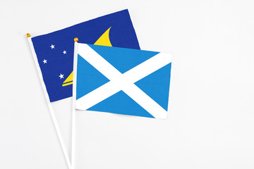 Scotland and Tokelau stick flags on white background. High quality fabric, miniature national flag. Peaceful global concept.White floor for copy space.