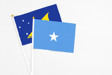 Somalia and Tokelau stick flags on white background. High quality fabric, miniature national flag. Peaceful global concept.White floor for copy space.