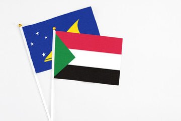 Sudan and Tokelau stick flags on white background. High quality fabric, miniature national flag. Peaceful global concept.White floor for copy space.